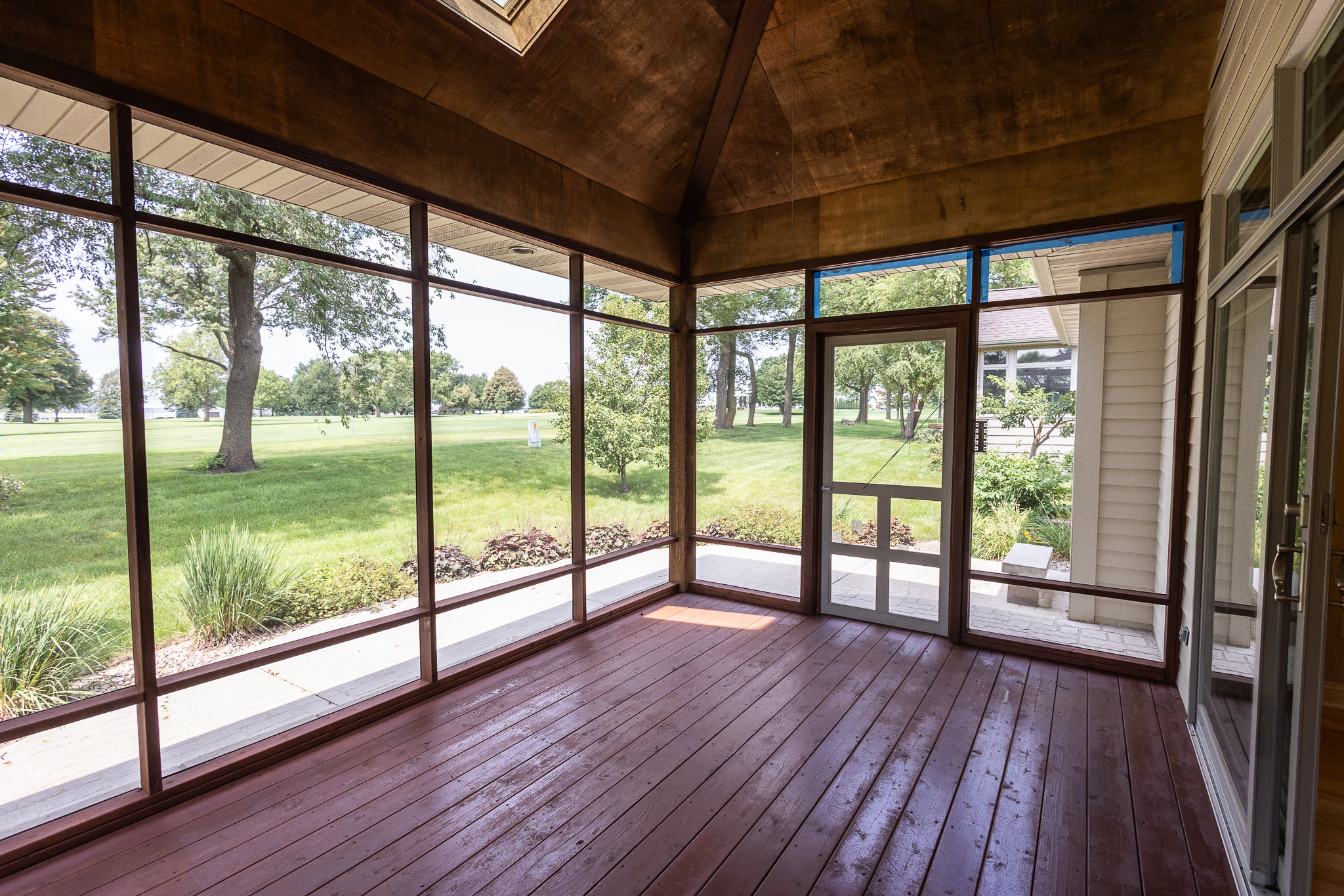 Screened porch with wood deck facing the golf course